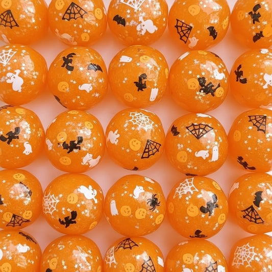 Orange Halloween-themed round beads with white ghosts, black bats, spiderwebs, and jack-o'-lanterns, shown in a close-up arrangement.